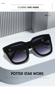 Detail of square black sunglasses with purple gradient lenses on a blue stand