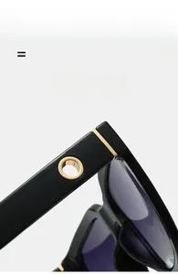 Macro detail of glossy black square sunglasses frame with golden metal ornaments