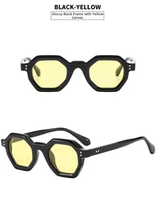 Detail view of glossy black hexagonal sunglasses with yellow lenses and metal rivets