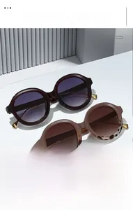 Detail view of retro oval sunglasses in deep wine and tortoiseshell with gold accents
