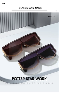 Detail view of retro shield sunglasses with gold metal accents on white pedestal