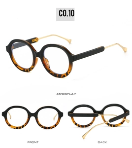 Detail view of oval sun glasses with black and tortoise frame and slim gold metal temples