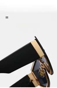 Detail of oversized rimless sunglasses featuring black-gold hinges and elastic temples