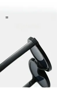 Detail of lightweight oval sunglasses featuring high-gloss black frames and elastic hinges