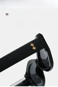 Détail de lunettes de soleil œil-de-chat noires avec branches de luxe ornées de strass