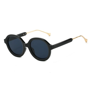Futuristic retro oval sunglasses with black frames and gold metal temples on white background