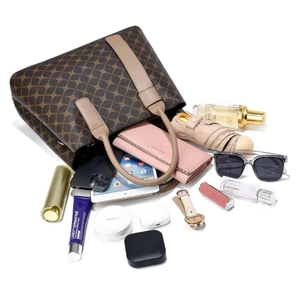 Detailed view showing large storage capacity of brown monogram tote bag with essentials
