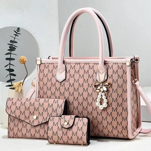 Detailed set of pink tote bag with matching wallet and pearl tassel in minimalist setting