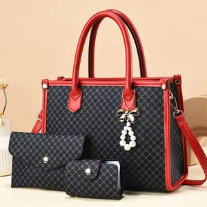 Detailed set of red and black tote bag with wallet and card holder on warm background