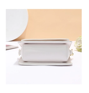 Vue détaillée d'un sac à main blanc en cuir avec des boucles dorées élégantes