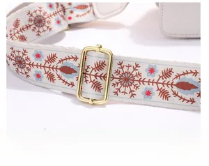 Détail de la bandoulière ethnique avec motifs floraux et boucle en métal doré