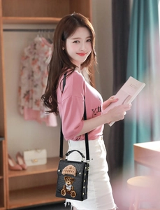 Detail of black crocodile texture mini bag with a 3D teddy bear patch decoration