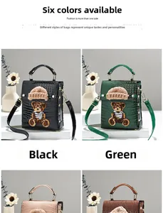 Close-up of crocodile pattern leather bag with detailed 3D bear embroidery and mini hat
