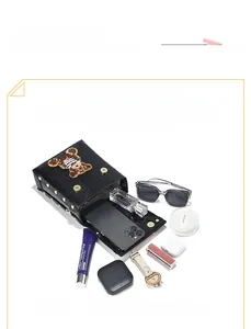 Capacity display of black croc-embossed phone bag featuring a cute teddy bear patch