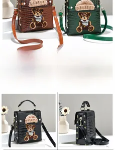 Detail showing crocodile texture and cute bear embroidery on mini square crossbody bags