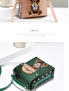 Detail of crossbody bag featuring crocodile texture, rivet trim and a plush bear patch