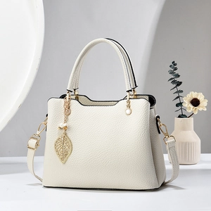 Elegante beige Damenhandtasche mit Kieselleder-Struktur und goldenem Blattanhänger