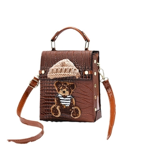 Brown faux crocodile leather crossbody bag with teddy bear patch and knitted hat decoration