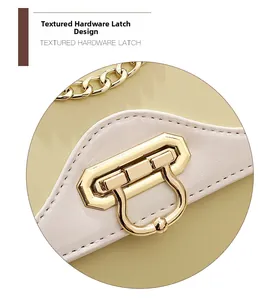 Detailed close-up of a golden textured hardware latch on a stylish leather crossbody bag