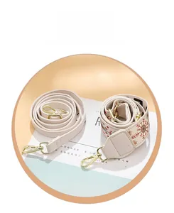 Detail of adjustable PU leather strap and wide embroidered fabric shoulder strap with gold hooks