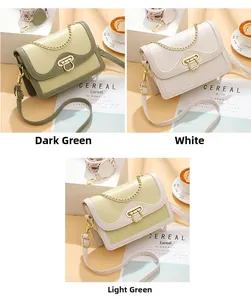 Detail of elegant shoulder bag with gold U-shaped buckle in dark green, white, and light green