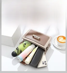 Détail du sac bicolore montrant sa grande capacité pour téléphone, lunettes et maquillage