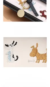 Détails de broderie de chien et ferrures dorées sur sac à main en cuir blanc élégant