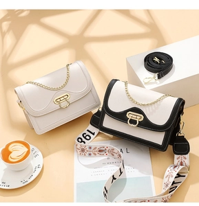 Detail of color-block crossbody bag with bohemian strap and gold buckle in warm sunlight