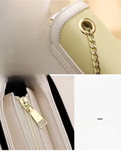 Detail of premium golden metal ring and smooth zipper hardware on a bicolor leather bag