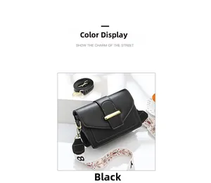 Détail du sac carré noir en cuir avec boucle dorée et bandoulière large imprimée