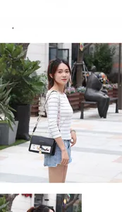 Détail d'un sac bandoulière bicolore avec broderie de chien et bandoulière ethnique