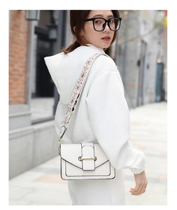 Détail du sac bandoulière blanc avec sangle brodée bohème et boucle dorée