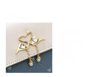 Detail of golden swan closure with crystals and pearl on square crossbody bag
