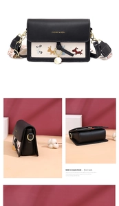 Détail du sac bandoulière bicolore avec broderies de chiens et pendentif doré