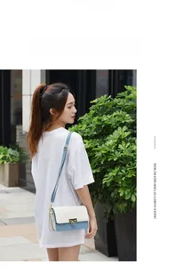 Photo de mannequin avec petit sac à bandoulière bleu et crème et fermoir doré
