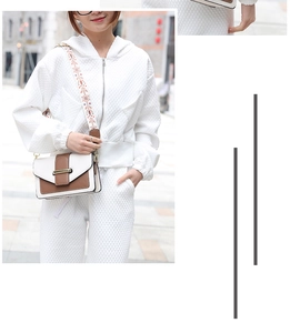 Détail du sac bandoulière blanc et marron avec sangle fleurie et boucle en métal