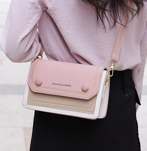 Détail du sac bandoulière patchwork rose et beige avec fermoir en métal et logo de marque