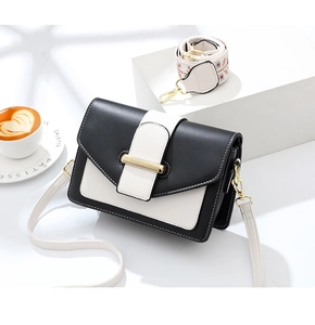 Détail du sac bandoulière noir et blanc avec boucle dorée et sangle à broderie florale