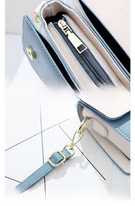 Gros plan détaillé de la garniture dorée polie et du cuir bleu texturé du sac carré chic