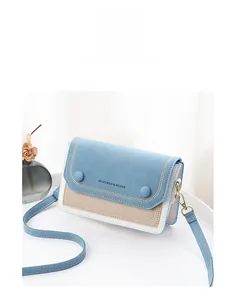 Détail du sac bandoulière tricolore avec panneaux bleu clair et fermoirs dorés chic