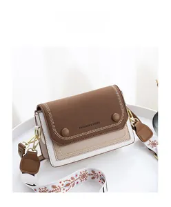Détail du sac bandoulière en cuir tricolore avec sangle ethnique et boucles dorées