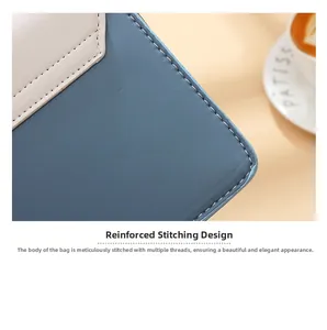 Close-up of beige and blue leather crossbody bag showing precision stitching and texture