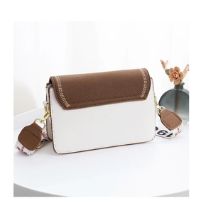 Détail d'un sac bandoulière bicolore en cuir avec coutures dorées et sangle large