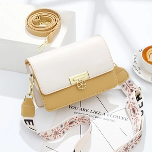 Dual-tone beige and yellow flap crossbody bag with gold flower buckle and wide woven strap