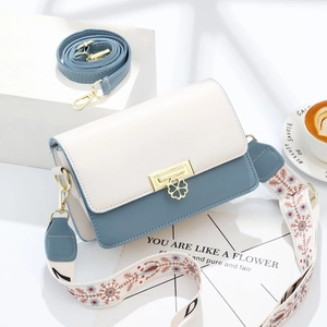 Sac bandoulière bicolore chic crème et bleu avec fermoir trèfle et sangle à fleurs brodée