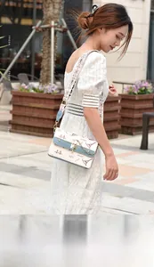 Detail of color-block crossbody bag with Eiffel Tower graffiti and patterned wide strap