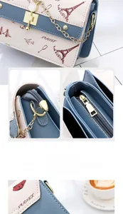 Detail of blue and white crossbody bag with Eiffel Tower prints and cat-shaped metal lock