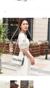 Detailed view of fashionable printed crossbody bag with metal chain and Eiffel Tower pattern