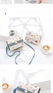 Detail of crossbody bag with French illustrations, metal lock, and colorful woven strap