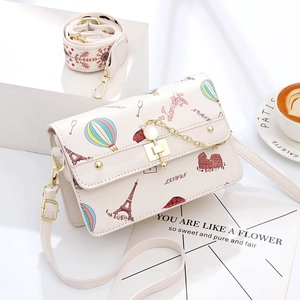 Sweet cream crossbody bag with Eiffel Tower prints and dual straps on minimalist background